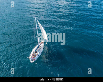 Lonely yacht isolato sotto la vela con altezza montante andando ancora in mare antenna vista superiore Foto Stock