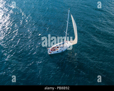 Lonely yacht isolato sotto la vela con altezza montante andando ancora in mare antenna vista superiore Foto Stock