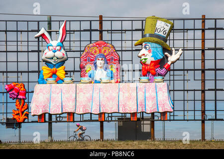 Blackpool, Lancashire, Regno Unito Meteo. 27/07/2018. Sunny per iniziare la giornata presso la costa come Mad Hatter Tea Party installazioni, parte delle luminarie spettacolari appaiono sul tratto del lungomare come i residenti locali, i ciclisti e i turisti al mattino potrete gustare il sun. Luminarie di Blackpool è un annuale festival delle luci, fondata nel 1879 e che si tiene ogni autunno in British località balneare di Blackpool sulla costa di Fylde Credito: MediaWorldImages/AlamyLiveNews Foto Stock