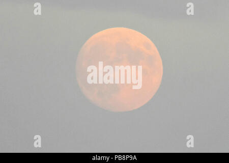 Mudeford Quay, Christchurch, Dorset, Regno Unito. Il 26 giugno 2018. Regno Unito Meteo. La quasi luna piena nel cielo sopra Mudeford Quay nel Dorset al tramonto su una calda serata. Credito Foto: Graham Hunt/Alamy Live News Foto Stock