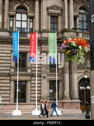 Glasgow, Regno Unito. Il 27 luglio 2018. Glasgow Campionati Europei preparati, 27 luglio 2018. Glasgow e Berlino ospiterà la cerimonia inaugurale dei Campionati Europei evento di sport con i principali sport tra cui atletica, sport acquatici, escursioni in bicicletta, ginnastica, canottaggio e triathlon con una nuova squadra di Golf Championships. I giochi saranno in scena ogni quattro anni a partire 2-12Agosto 2018. Grande banner colorati pubblicizzare i giochi al di fuori di Glasgow City Chambers decorate con cesti di fiori Foto Stock