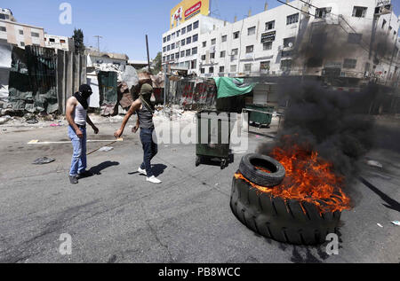 Hebron, West Bank, Territorio palestinese. 27 Luglio, 2018. I dimostranti palestinesi bruciano pneumatici durante scontri a seguito di una dimostrazione in Cisgiordania città di Hebron, il 27 luglio 2018 Credit: Wisam Hashlamoun APA/images/ZUMA filo/Alamy Live News Foto Stock