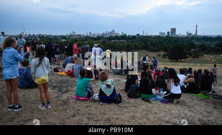 Londra, Regno Unito. Il 27 luglio 2018. Le persone si radunano in Primrose Hill per vedere il Lunar Eclipse, noto come 'Luna di sangue. Aspetta di vedere sorgere la luna oltre la cattedrale di St Paul che appaiono di colore rosso di colore arancione, come la terra passa tra la luna e il sole, il loro punto di vista di questo secolo più lunga eclissi lunare è stata oscurata dalla nube bassa. Credito: Stephen Chung / Alamy Live News Foto Stock