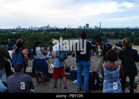 Londra, Regno Unito. Il 27 luglio 2018. Le persone si radunano in Primrose Hill per vedere il Lunar Eclipse, noto come 'Luna di sangue. Aspetta di vedere sorgere la luna oltre la cattedrale di St Paul che appaiono di colore rosso di colore arancione, come la terra passa tra la luna e il sole, il loro punto di vista di questo secolo più lunga eclissi lunare è stata oscurata dalla nube bassa. Credito: Stephen Chung / Alamy Live News Foto Stock