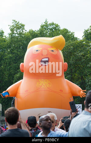 Il Trump Baby Blimp essendo sfilavano attorno a Piazza del Parlamento, LONDRA, REGNO UNITO, AL #BringTheNoise donna marzo Anti Donald Trump manifestazione di protesta. Foto Stock