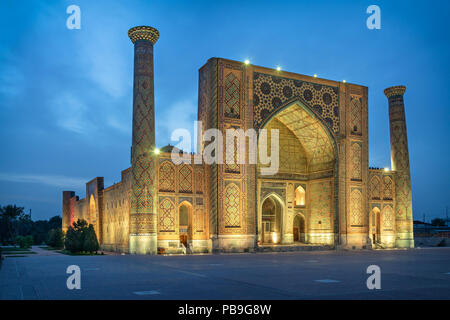 Ulugh Beg Madrasah situato sulla famosa piazza Registan al crepuscolo in Samarcanda, Uzbekistan Foto Stock