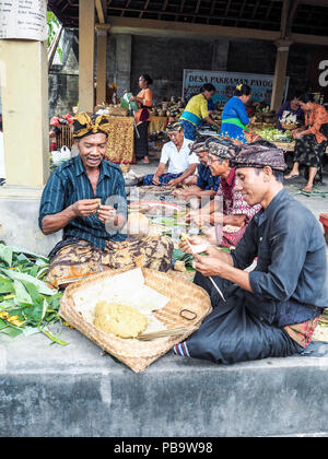 Ubud, Bali - Aprile 2017: due uomini rendendo il tradizionale design Balinese satay per Nyepi festival in un tempio locale Foto Stock