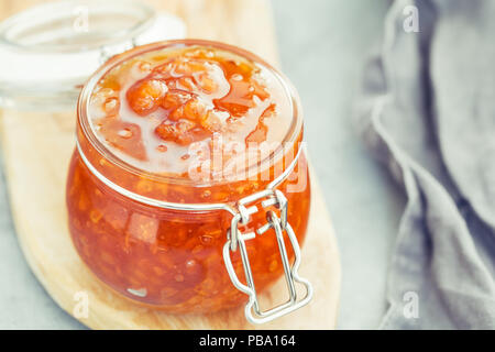 Vaso di vetro con cloudberry inceppamento. Cucina nordica. Foto Stock