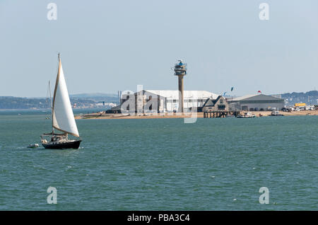 Barca a vela passando Calshot centro attività sulle rive del Solent, Calshot Spit, Southampton, England Regno Unito Foto Stock