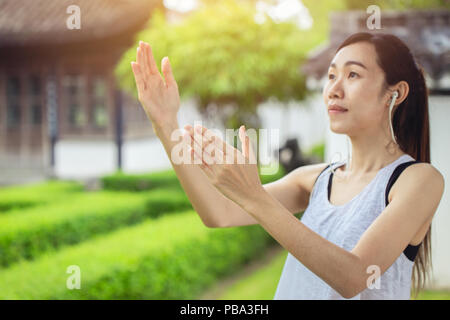 Tai Chi, Cinese girl teen pratica yin yang forza pacifica in giardino per una buona salute. messa a fuoco selettiva a portata di mano Foto Stock