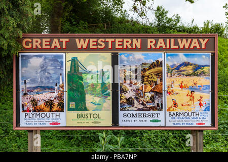 Annunci pubblicitari di poster di vacanza di Great Western Railway su una piattaforma di stazione, Inghilterra Foto Stock