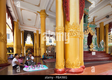 I devoti pregando nel tempio con la Sacra reliquia dei capelli lavando bene immagine del Buddah, Shwedagon pagoda Yangon, Myanmar, Asia Foto Stock