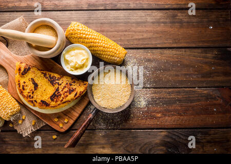 Tipica cucina Venezuelana, vista dall'alto di un tavolo di legno con diversi ingredienti per la preparazione di Cachapas con formaggio, mais, burro, grano macinato Foto Stock