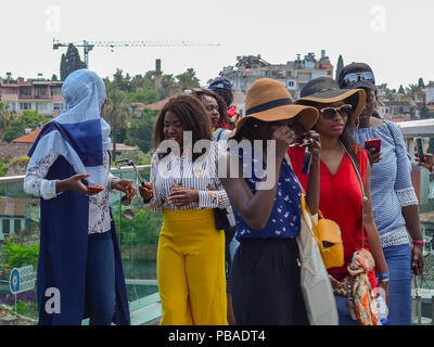 La Turchia, Antalya, 10 maggio 2018. Un gruppo di giovani donne africane in luminose vestiti sulla piattaforma di osservazione nella città vecchia di ispezionare il punto di riferimento. African Foto Stock