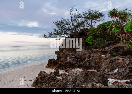 Marea all'alba in corrispondenza di un ingresso di roccia Foto Stock