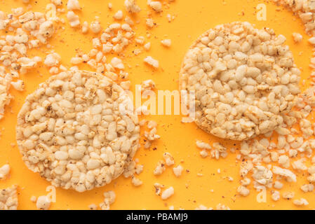 Lay piatto croccante e torte di riso su sfondo giallo, overhead vista dall'alto in basso Foto Stock