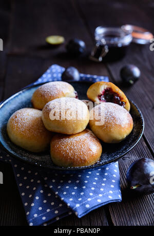 Dolce tradizionale cotto panini riempiti con marmellata di prugne e costellata di zucchero a velo Foto Stock