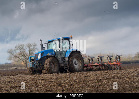 L'aratura di un campo con una New Holland T7030 e un solco 5 reversibile aratro Kuhn, North Yorkshire, Regno Unito. Foto Stock
