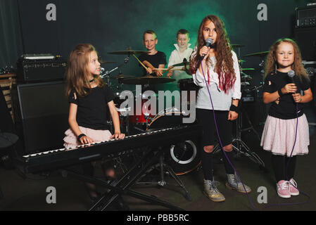 Dei bambini felici di cantare e suonare la musica in studio Foto Stock