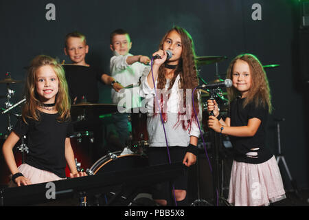 Dei bambini felici di cantare e suonare la musica in studio Foto Stock