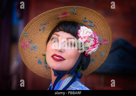 Chiudi, vista frontale ritratto di attraente, chic, femmina caucasica in posa in un bel cappello a larga sposa, Black Country Museum, evento 1940s. Foto Stock