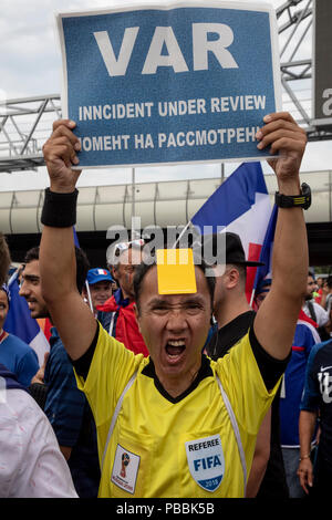 Un appassionato di calcio in uniforme di un arbitro della Coppa del Mondo FIFA 2018 contiene un poster con le parole 'VAR' (Video assistente arbitro) al Luzhniki stadium Foto Stock