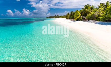 Bellissima spiaggia con palme, moody sky. Estate vacanze Viaggi Vacanze il concetto di sfondo. Maldive Paradise Beach. Viaggi di lusso vacanze estate Foto Stock