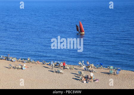 I turisti sulla spiaggia di ciottoli nel villaggio di birra in East Devon Foto Stock