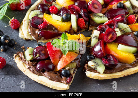 Pizza menu. Frutta estiva berry pizza con impasto di cioccolato. Vitamina dessert. Foto Stock
