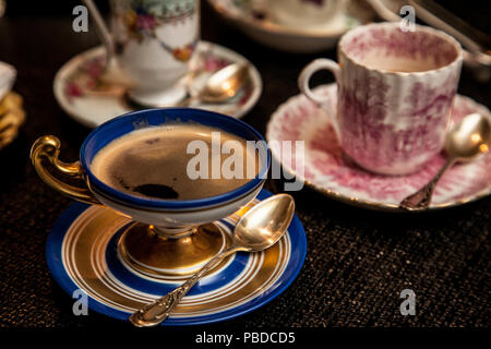Elegante tazza cooffe al buio su un tavolo di legno. pomeriggio fantasia cooffe concetto. Foto Stock