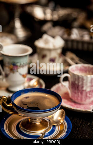 Elegante tazza cooffe al buio su un tavolo di legno. pomeriggio fantasia cooffe concetto. Foto Stock