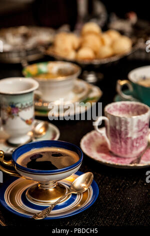 Elegante tazza cooffe al buio su un tavolo di legno. pomeriggio fantasia cooffe concetto. Foto Stock