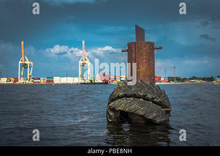 Pneumatici vecchi su un palo metallico nel contenitore terminale nella Riga, Lettonia in estate giorno nuvoloso, paesaggio Foto Stock