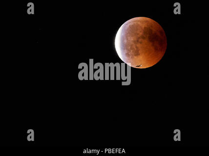 Hohenschwangau, Germania. Il 27 luglio 2018. Un aereo passa la luna di sangue, Lunar Eclipse in cielo al Castello di Neuschwanstein (costruito da re Ludwig II, 2nd, visto a Hohenschwangau vicino a Füssen, Baviera, Germania, 27 luglio 2018. La luna spostato nell'ombra della Terra. Con 1 ora, 43 minuti, sua la più lunga eclissi lunare nel XXI secolo, © Peter Schatz / Alamy Live News Foto Stock