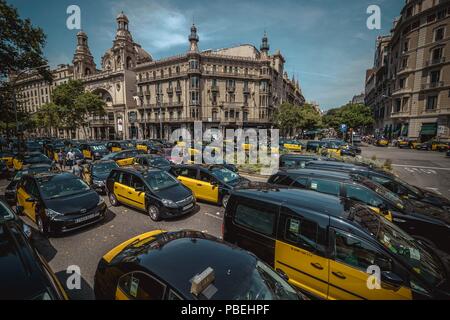 Barcellona, Spagna. 28 Luglio 2018: Taxi driver un blocco di giunzione nevralgici nel centro della città di Barcellona per protestare contro il crescente uso di ride-salutando i servizi che essi considerano una concorrenza sleale nel corso di un numero illimitato di sciopero. Credito: Matthias Oesterle/Alamy Live News Foto Stock