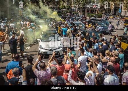 Barcellona, Spagna. 28 Luglio 2018: Taxi driver un blocco di giunzione nevralgici nel centro della città di Barcellona per protestare contro il crescente uso di ride-salutando i servizi che essi considerano una concorrenza sleale nel corso di un numero illimitato di sciopero. Credito: Matthias Oesterle/Alamy Live News Foto Stock