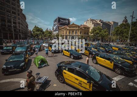 Barcellona, Spagna. 28 Luglio 2018: Taxi driver un blocco di giunzione nevralgici nel centro della città di Barcellona per protestare contro il crescente uso di ride-salutando i servizi che essi considerano una concorrenza sleale nel corso di un numero illimitato di sciopero. Credito: Matthias Oesterle/Alamy Live News Foto Stock
