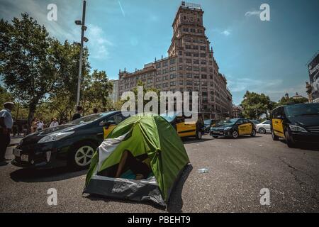 Barcellona, Spagna. 28 Luglio 2018: Taxi driver un blocco di giunzione nevralgici nel centro della città di Barcellona per protestare contro il crescente uso di ride-salutando i servizi che essi considerano una concorrenza sleale nel corso di un numero illimitato di sciopero. Credito: Matthias Oesterle/Alamy Live News Foto Stock
