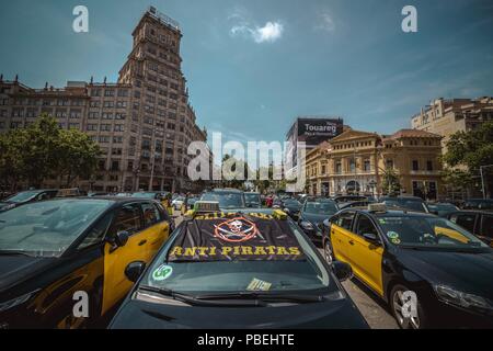 Barcellona, Spagna. 28 Luglio 2018: Taxi driver un blocco di giunzione nevralgici nel centro della città di Barcellona per protestare contro il crescente uso di ride-salutando i servizi che essi considerano una concorrenza sleale nel corso di un numero illimitato di sciopero. Credito: Matthias Oesterle/Alamy Live News Foto Stock