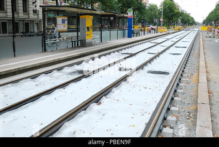 Leipzig, Germania. 28 Luglio, 2018. Una fermata del tram di Lipsia la società di trasporti pubblici Leipziger Verkehrsbetriebe (LVB) nel sud della città. Ciò che appare come un manto di neve sulle piste è in realtà il cosiddetto vello di drenaggio, che è utilizzato in via lavori di costruzione per impedire diversi materiali da costruzione da miscelazione. Credito: Sebastian Willnow/dpa-Zentralbild/dpa/Alamy Live News Foto Stock