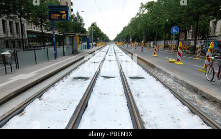 Leipzig, Germania. 28 Luglio, 2018. Una fermata del tram di Lipsia la società di trasporti pubblici Leipziger Verkehrsbetriebe (LVB) nel sud della città. Ciò che appare come un manto di neve sulle piste è in realtà il cosiddetto vello di drenaggio, che è utilizzato in via lavori di costruzione per impedire diversi materiali da costruzione da miscelazione. Credito: Sebastian Willnow/dpa-Zentralbild/dpa/Alamy Live News Foto Stock