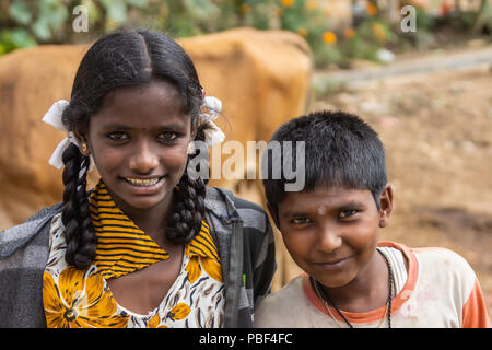 Belathur, Karnataka, India - 1 Novembre 2013: primo piano della ragazza sorridente e giovane ragazzo congedandosi per uscire pilgirms durante la cerimonia. Blac lungo Foto Stock