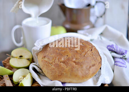 Homebaked pane. prodotti da forno. il latte in una brocca. vintage tovaglioli e tovaglia. tagliare apple Foto Stock
