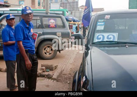 Due Khmer Partito Repubblicano sostenitori stand su una strada prima di prendere parte a una pre-elettorale rally in Kampong Cham, Cambogia. Foto Stock