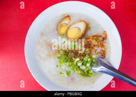 Riso asiatico zuppa, porridge, con costolette di maiale e marrone e uova sode, popolare colazione piatto nella maggior parte dei paesi dell'Asia orientale Foto Stock
