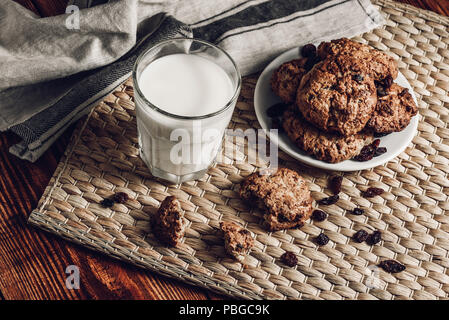 Farina di avena cookie sulla piastra con il latte in bottiglie di vetro Foto Stock