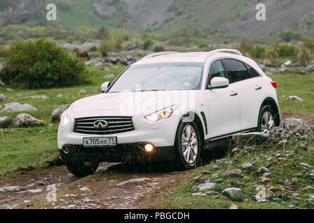 Stepantsminda Gergeti, Georgia - 23 Maggio 2016: Bianco Infiniti FX30d turbo diesel auto SUV sulla strada di campagna in estate sulle montagne paesaggio. La Infiniti ho Foto Stock