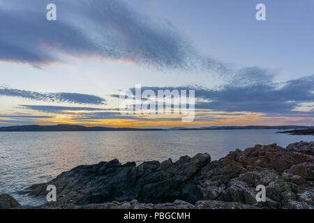 Little Cumbrae & Millport sotto il cielo cupo in estate dalle sponde rocciose di Seamill Foto Stock