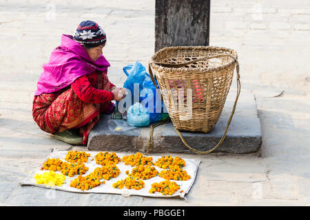 Donna locale di vendita fiori di tagete (sayapatri) in Patan Nepal Foto Stock