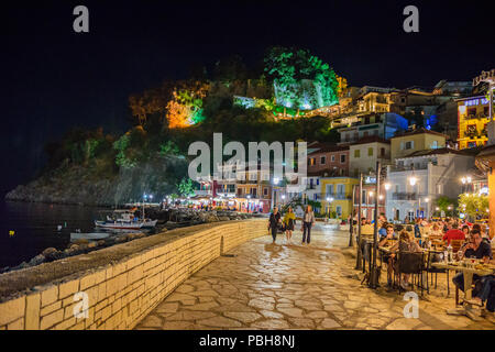 La fantastica città costiera di Parga di notte. Turisti e visitatori di camminare lungo la costa vicino alla bellissima decorata dai negozi e dai ristoranti. Parga Foto Stock